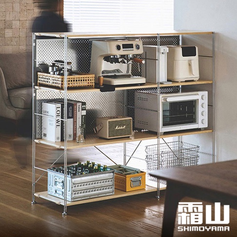 60公分寬不鏽鋼三層收納置物架，淺木色層板搭配銀色金屬支架，上方擺放咖啡機、濾水壺、小烤箱，中間層有音響、書籍，下方層有啤酒箱、置物盒，整體簡約實用。