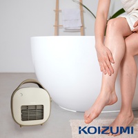 米色迷你陶瓷電暖器，帶有棕色提把，前方有灰色網狀出風口及指示燈。