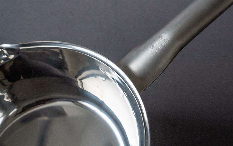 三層不鏽鋼雪平鍋，鍋身與鍋柄皆為銀色不鏽鋼材質，鍋柄上刻有「KONO」及「MADE IN JAPAN」字樣。