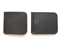 兩個黑色皮革製成的橫式對折鈔票夾，邊緣以黑色縫線車縫，底部有金色金屬夾。