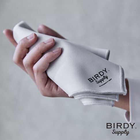 一隻手拿著一塊淺灰色、超細纖維材質的廚房擦拭巾，上面印有黑色「BIRDY. Supply」Logo。