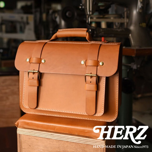 經典雙扣設計的棕色皮革單肩包，帶有提把和可調節的皮帶。包包採用高品質皮革製成，雙扣設計簡潔實用。