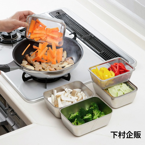 廚房料理場景中，一隻手正將不鏽鋼瀝水網籃中的切塊紅蘿蔔倒入平底鍋，旁邊擺放著多個不鏽鋼調理保存盒，分別盛裝著切好的香菇、青花菜、高麗菜以及彩色甜椒，整體呈現井然有序的備料狀態，下方印有下村企販字樣。