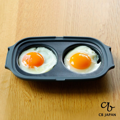 CB JAPAN 品牌標誌旁的雙圓煎鍋，鍋內有兩個烹調好的荷包蛋。