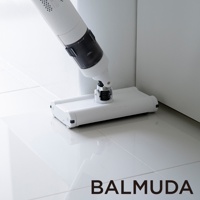 白色無線吸塵器，配備可旋轉吸頭，正在清潔有光澤的白色地板，地板上反射出產品的光澤。