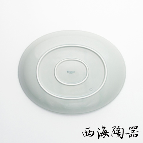 淺灰色波佐見燒陶瓷橢圓餐盤，底部刻有「Common JAPAN」字樣，盤底有同心圓紋路。
