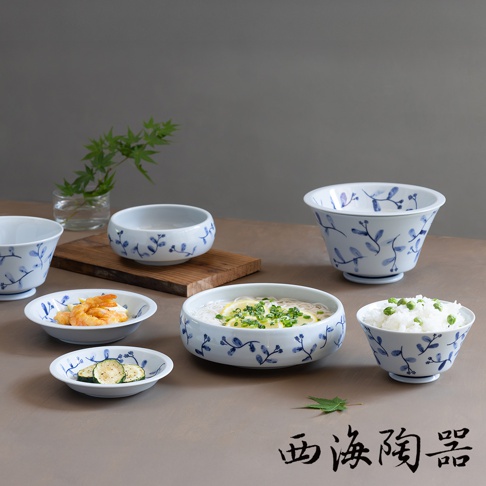 波佐見燒藍花紋陶瓷深碟盤組，包含盛裝日式冷麵、米飯、炸蝦和櫛瓜片等多種日式料理的碗盤，盤身繪有精緻的藍色植物花紋。