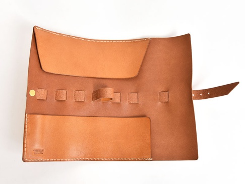 職人手作皮革捲捲收納筆袋，採用棕色皮革製成，設有筆插、鈕扣、皮繩及內袋，設計簡潔實用。