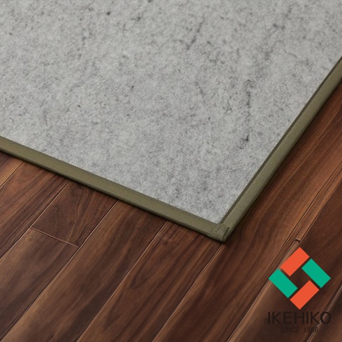 YUME 藺草組合式五折疊榻榻米睡墊，淺灰色藺草表面，帶有深綠色包邊，鋪設在深棕色木地板上。