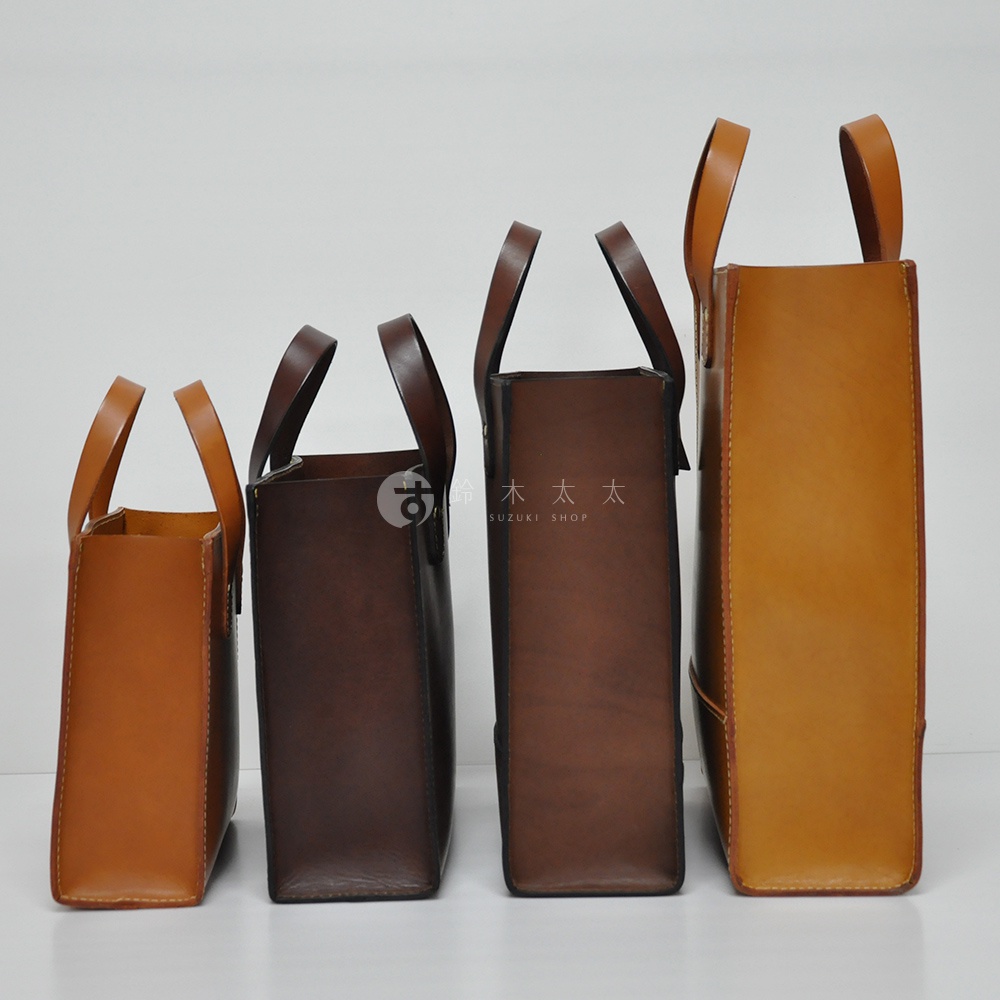 四款職人手作皮革直式托特包，從左至右分別為淺棕、深棕、咖啡色、淺黃褐色，皆為皮革材質，具備提把。