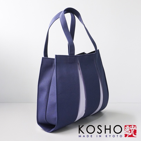 深藍色棉帆布製成的扇形托特包，側邊有淺紫色布料拼接，設計簡潔。