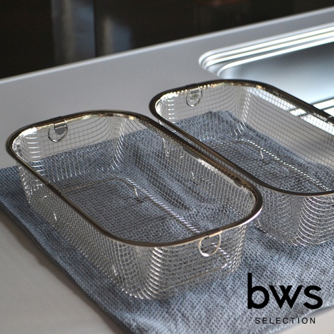 兩個簡約設計的不鏽鋼深型瀝水籃，網狀結構，框架和提把為銀色金屬，其中一個籃子放置在藍灰色布料上。