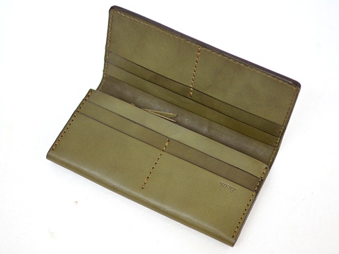 橄欖綠皮革長夾，打開狀態，展示內部多個卡片夾層與縫線細節，右下角有壓印的「HERZ」品牌標誌。