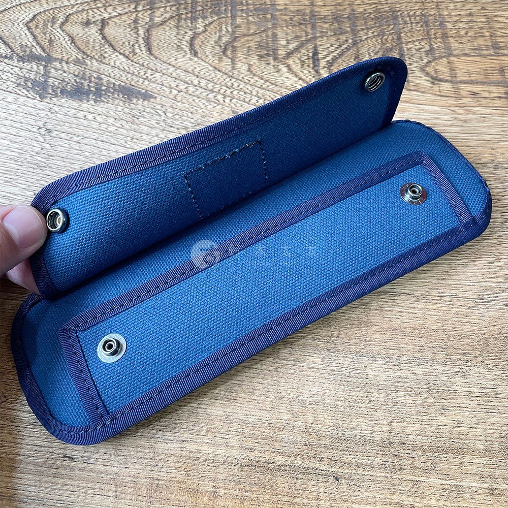 深藍色純棉帆布製成的肩墊，帶有對比色的滾邊和金屬按扣，用於固定。