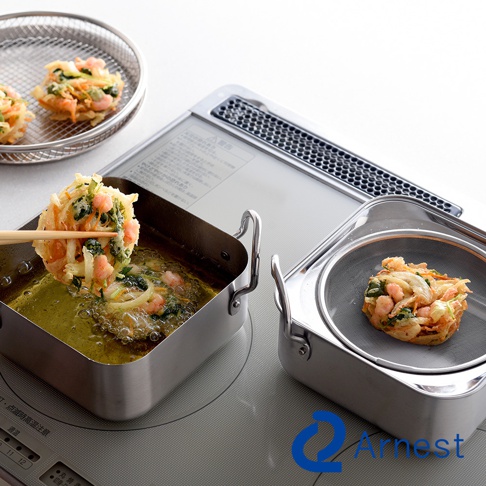 一個不鏽鋼方型炸物鍋組，鍋內有金黃色油炸物，並有附濾油網的鍋子，鍋旁還有一個濾油網盤，盤中放有炸物。