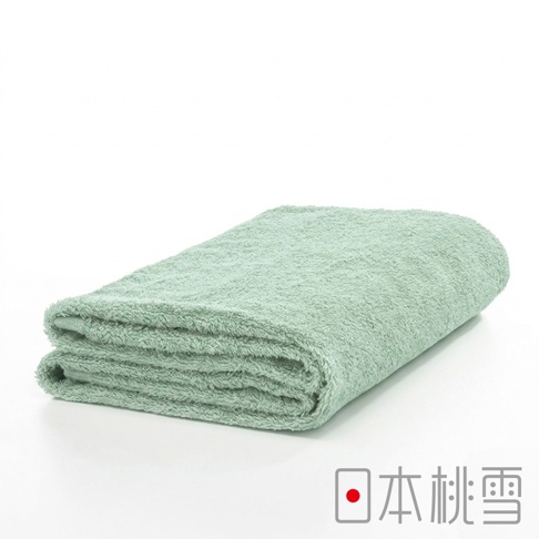 一條對折疊放的日本桃雪品牌淡綠色精梳棉浴巾，表面呈現柔軟蓬鬆的毛圈質感，整體風格簡約素雅，右下角印有日本桃雪的品牌標誌。