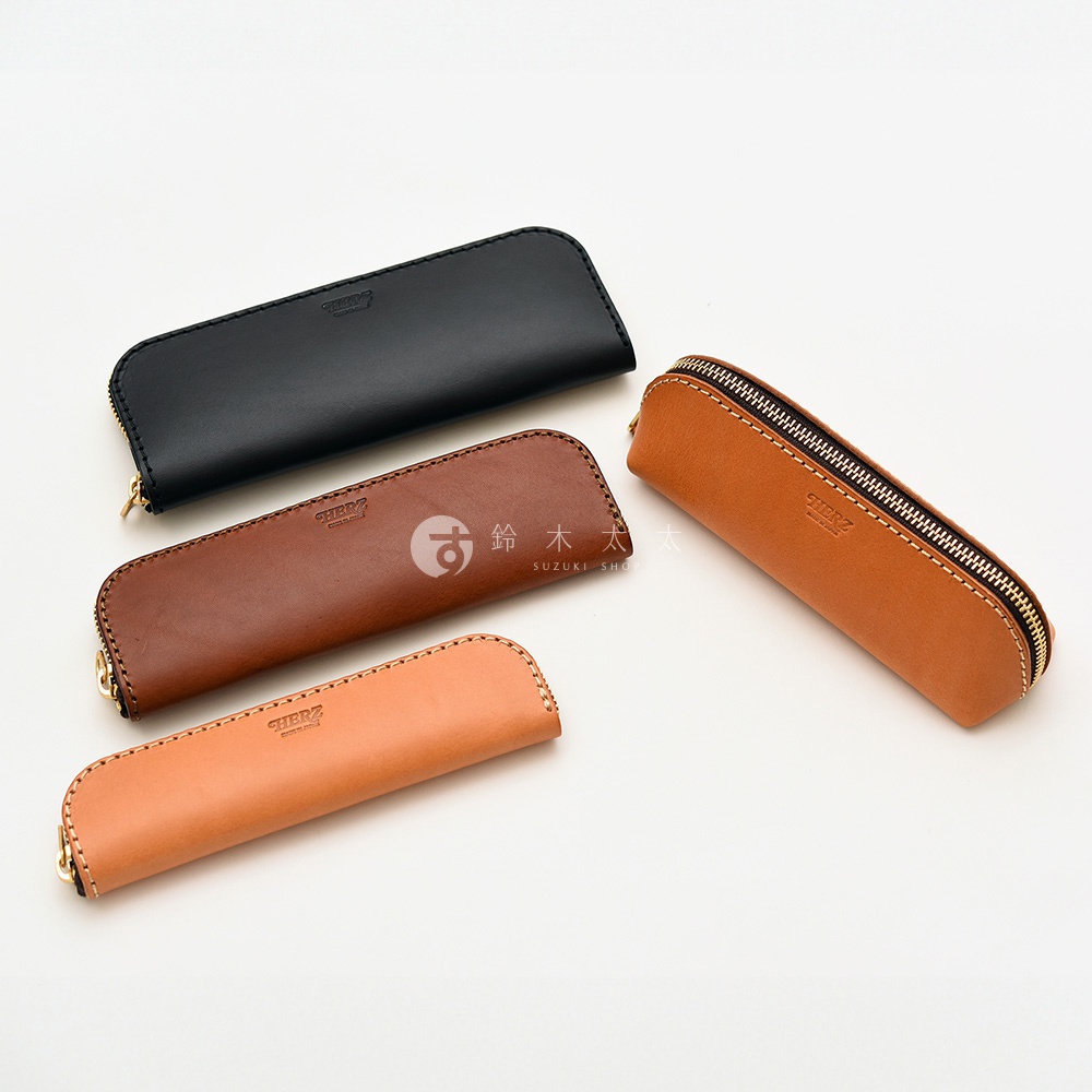 黑色、咖啡色和淺棕色的皮革筆袋，其中兩個有拉鍊，表面印有品牌標誌。