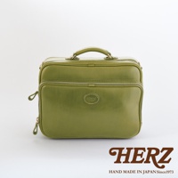 職人手作皮革兩用商務公事包，橄欖綠色，配有頂部提把、雙拉鍊開口及前方拉鍊口袋，中央飾有圓形品牌標誌。