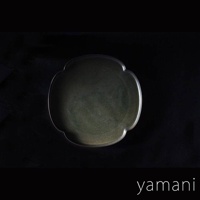 Tsudoi 黑鐵釉美濃燒花型盤，呈現深邃的墨綠色調，材質為陶瓷，具有獨特的花瓣造型邊緣，質感細膩。