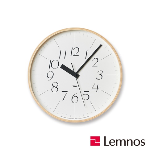 RIKI Lightness時鐘(L)為圓形設計，具有淺木色邊框，白色錶盤上印有黑色阿拉伯數字時標及細長刻度線。時針和分針皆為黑色，造型簡潔。