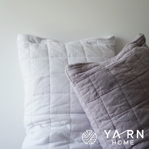 兩個 UKIHA 脫脂棉混紗速乾格紋枕套，分別為白色和淺灰色，表面有細緻的格紋縫線。