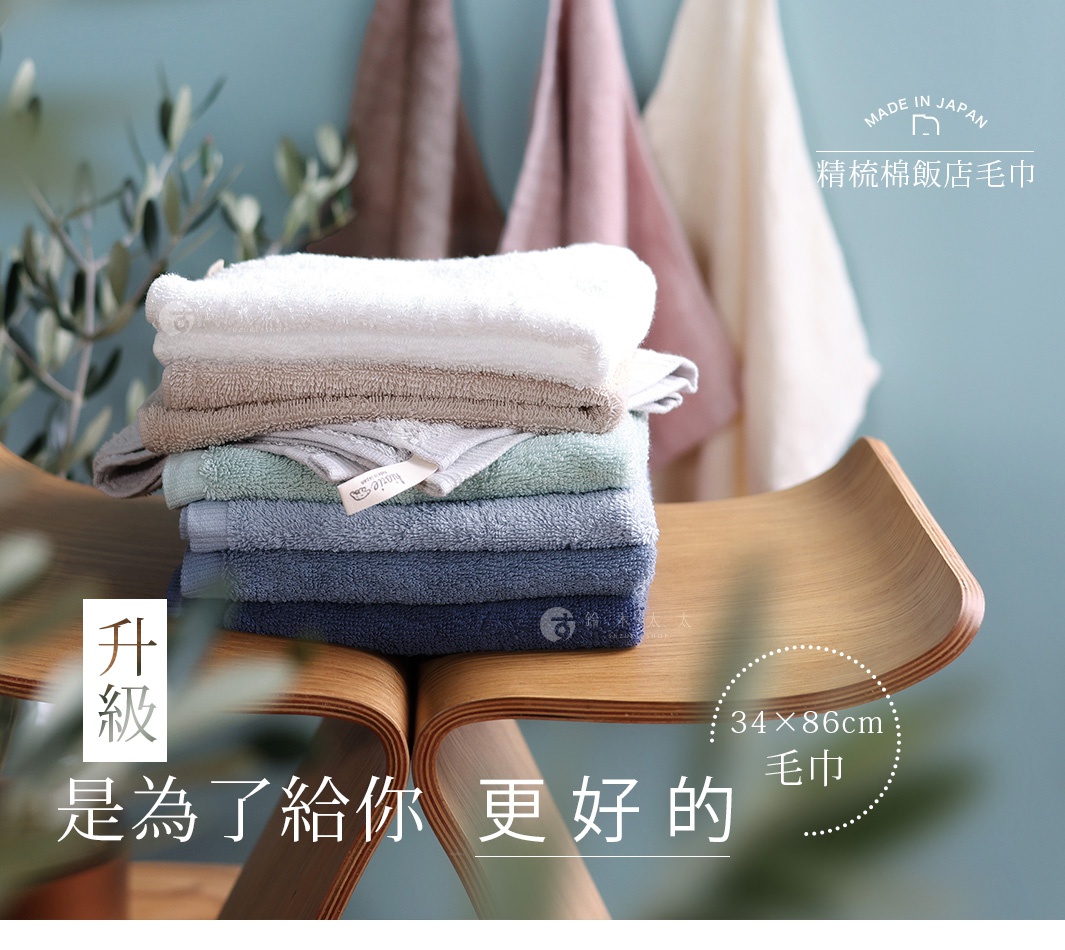 圖片文字：精梳棉飯店毛巾，升級是為了給你更好的，尺寸為34乘86公分的毛巾，由多條不同顏色、層疊堆放在木製椅上的飯店級精梳棉毛巾，背景處有吊掛的毛巾，整體呈現質感與舒適感。