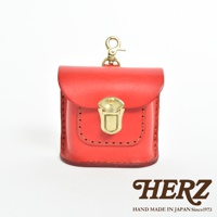 紅色職人手作皮革耳機收納包，帶有黃銅色金屬釦和掛環，皮革表面有縫線裝飾。