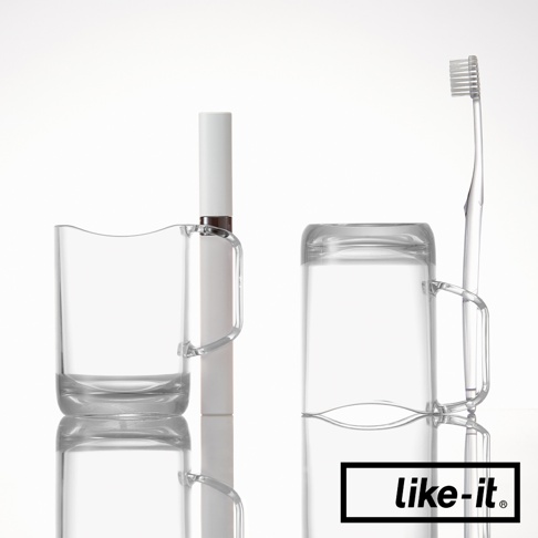 兩個透明塑膠漱口杯，一個杯內放置白色牙膏，另一杯倒置，旁邊立著一支透明塑膠牙刷。