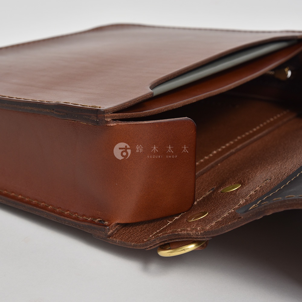 職人手作皮革雙口袋兩用單肩包 A-19，展示包款外側棕色皮革細節，包含縫線、口袋翻蓋設計與金屬釦環。