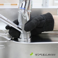 一隻戴著黑色針織材質萬用清潔手套的手，正在清潔銀色金屬水龍頭。