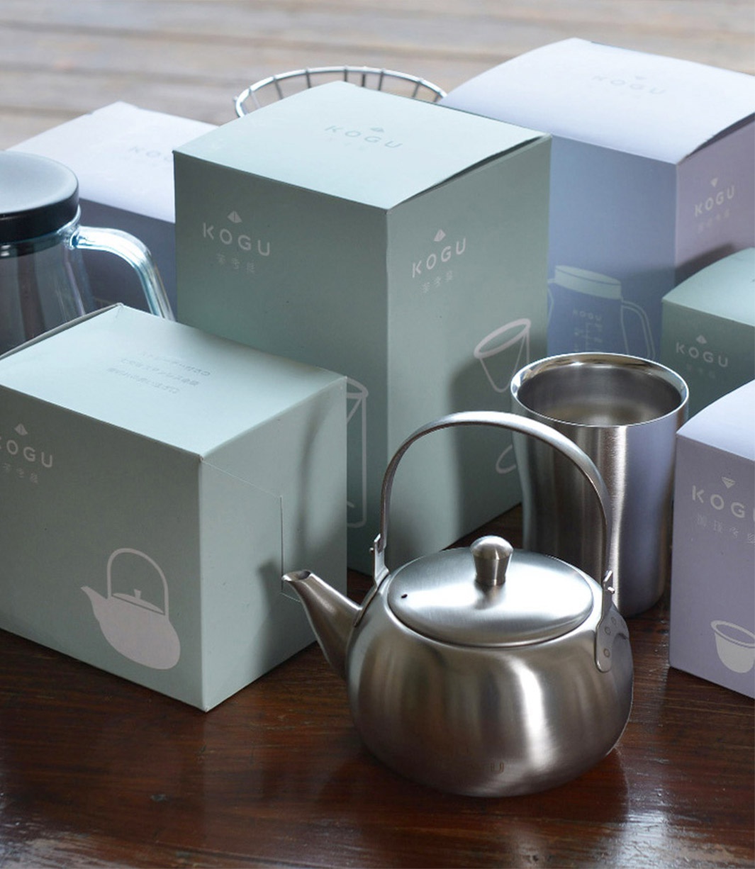 日製18-8不鏽鋼儲豆罐，搭配同材質量匙，罐身銀色，質感細緻，周圍擺放著同品牌系列產品的淺綠色、淺藍色紙盒包裝。