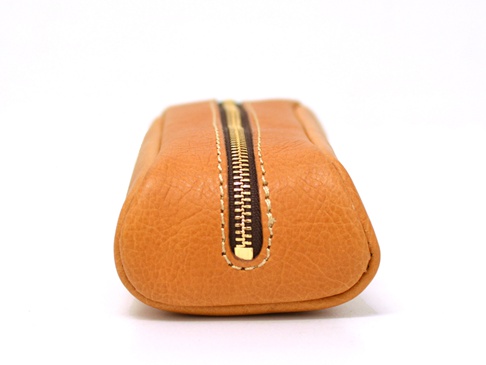 職人手作皮革圓角收納筆袋 (KP-1)，淺棕色牛皮材質，帶有金色拉鍊，整體呈圓潤的長條狀，適合收納文具。