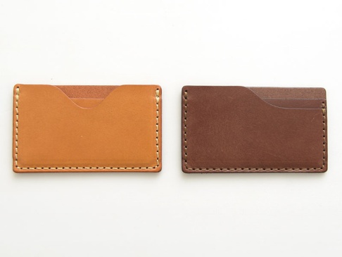 兩款職人手作皮革卡片夾，一款為淺棕色，另一款為深棕色，皆採用縫線工藝，設計簡約，可容納多張卡片。