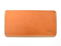 職人手作皮革紙鈔收納夾，棕褐色牛皮材質，邊緣縫線清晰，右下方壓印有「HERZ」品牌標誌及「MADE IN JAPAN」字樣。