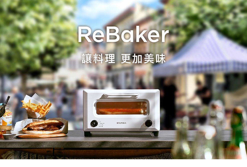 ReBaker 烤麵包機，白色機身，配有透明玻璃門，可見內部正在烘烤的吐司。機身正面有黑色旋鈕及按鈕。