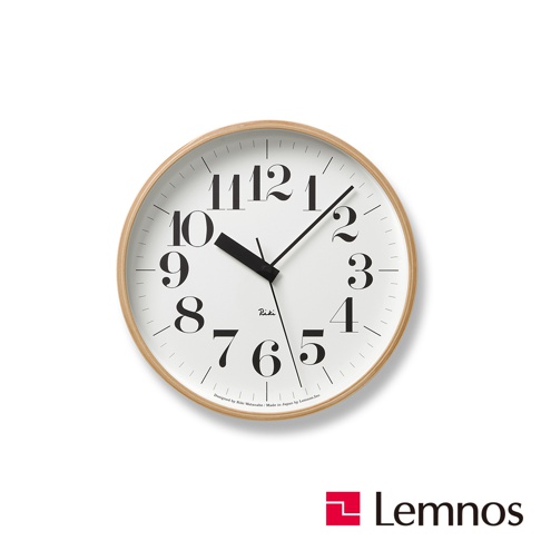RIKI 時鐘(M) 是一款圓形壁掛時鐘，白色錶盤搭配黑色阿拉伯數字時標和指針。時鐘外框為淺木紋材質，整體設計簡潔。