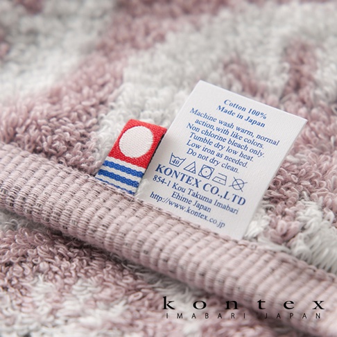 KONTEX 品牌標籤，顯示為純棉材質，可在溫水常規洗滌，不可漂白，可低溫烘乾，並說明了低溫熨燙的要求，以及不可乾洗。