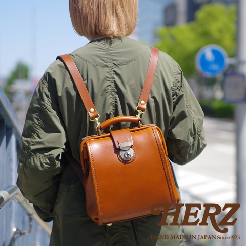 職人手作皮革迷你後背醫生包，採用棕色光滑皮革製成，配有黃銅色金屬扣環和可調節肩帶。