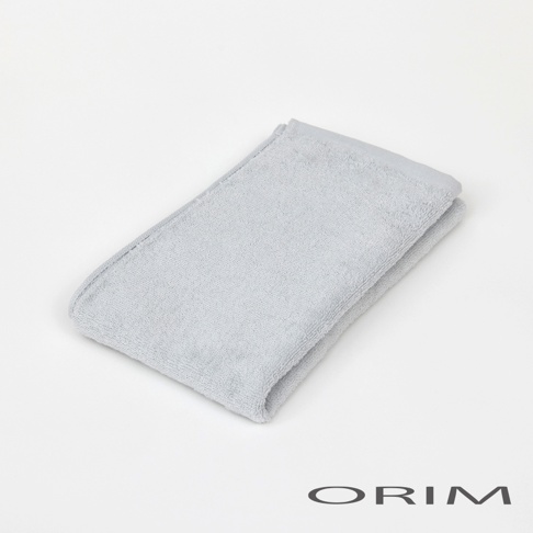 淺灰色柔軟棉質浴巾，帶有細緻織紋，對折呈現。