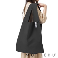 一款黑色大容量摺疊環保隨行袋，由輕便耐用的材質製成，擁有寬版提把，方便肩背，袋身側面有一個白色小標籤。