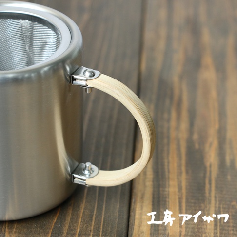 霧面不鏽鋼直筒茶壺，側邊附有淺木色竹製手把，壺口有細緻濾網。