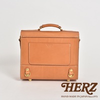 皮革學院風三用迷你後背包，呈現天然皮革的溫潤色澤，方形箱型設計，正面有品牌壓印與立體口袋，搭配金屬扣環與提把，風格簡約復古。