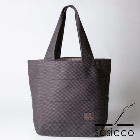 一件深灰色三河木綿刺子織大容量托特包，包身有橫向縫線，右下角有品牌標誌。