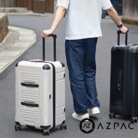 兩款 AZPAC Trucker 20吋旅行箱，一款為淺色，另一款為黑色，皆配備防爆拉鍊與可伸縮拉桿。