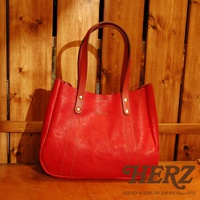 紅色皮革托特包，配有兩條皮革提把，包身有縫線裝飾，經典簡約設計。