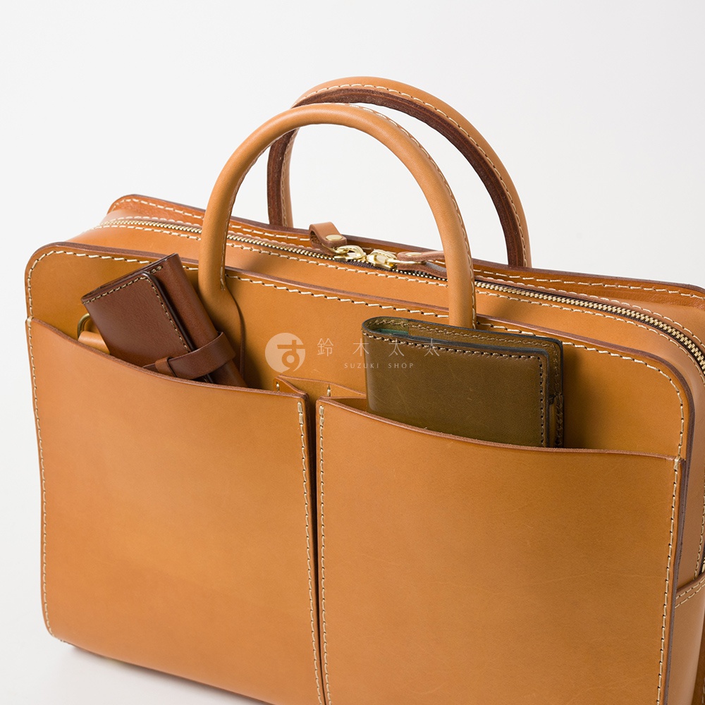 淺棕色皮革雙口袋兩用公事包，內有兩個皮夾，以白色縫線勾勒出包身線條，結構簡潔。