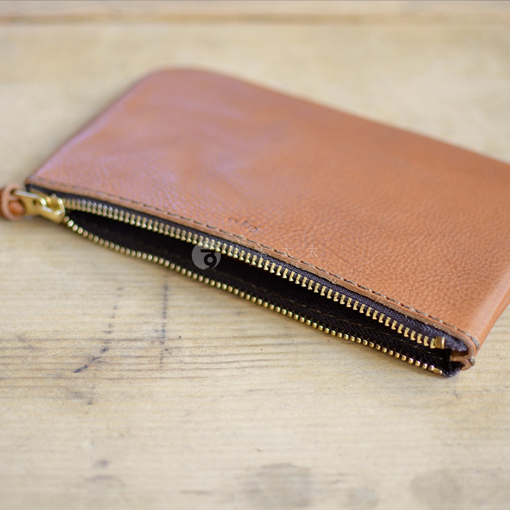 職人手作皮革Organ拉鍊式小物收納袋，採用淺棕色皮革，搭配金色拉鍊，質感細膩，適合收納小物。