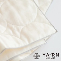 一條米白色、棉混紡材質的廚房拭巾，表面有縫製的圓形紋路，邊緣以灰色滾邊包覆，右下角有「YARN HOME」品牌標誌。