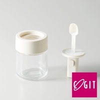 一個透明玻璃罐，搭配米白色蓋子，旁邊是一個米白色的一鍵伸縮量匙裝置，量匙為白色。