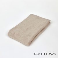 一條米色、柔軟的純棉迷你毛巾，織有細緻紋理，對折後放置於白色背景上，右下角有 ORIM 品牌標誌。